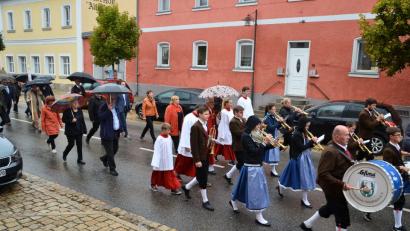 Bild: fjo
Die Teilnehmer des Kirchenzugs zum Patrozinium schützen sich mit Regenschirmen. Für die Musikanten der Blaskapelle ist dies nur bedingt möglich.