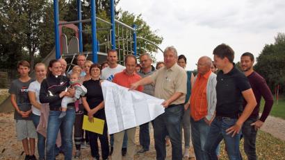 Bild: sön
Zahlreiche Interessierte kommen zum Vor-Ort-Termin auf den bisherigen Spielplatz, wo Bürgermeister Markus Dollacker gemeinsam mit den Architekten Stephan und Martina Dietrich (ab Viertem von rechts) vom Planungsbüro Stadt und Raum Amberg den Bebauungsplan mit Verlegung des Spielplatzes vorstellten.