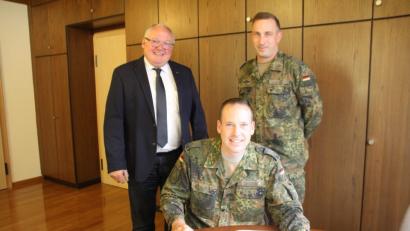 Bild: frd
Mit einer Widmung und einem Abschiedsgruß trug sich Obersleutnant Las Obst (stehend rechts) in das Gästebuch ein und Oberstleutnant Michael Zweers merkte im Gästebuch an, dass er sich auf seine neue Aufgabe in Oberviechtach freue. Beiden wünschte Bürgermeister Heinz Weigl (stehend links) für ihre neuen Aufgaben die nötige Portion „Soldatenglück“.