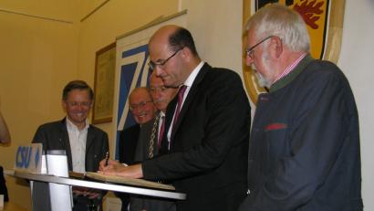 Bild: öt
Staatsminister Albert Füracker (Zweiter von rechts) trug sich beim Festakt anlässlich des 70. Gründungsjubiläums des CSU-Ortsverbands Neusorg in das Goldene Buch der Gemeinde Neusorg ein. Mit auf dem Bild: MdL Tobias Reiß (von links) zweiter Bürgermeister Dr. Günther Fütterer, Gemeindeoberhaupt Peter König und dritter Bürgermeister Karl Lenhard (rechts).