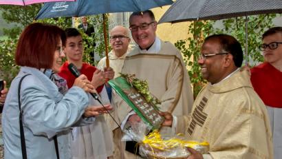 Bild: bas
Kindergartenleiterin Frau Gertraud Prösl überreicht Pfarrer Moses Gudapati symbolhaft Brot und Salz als Geschenk für den Einzug ins neu renovierte Pfarrhaus.