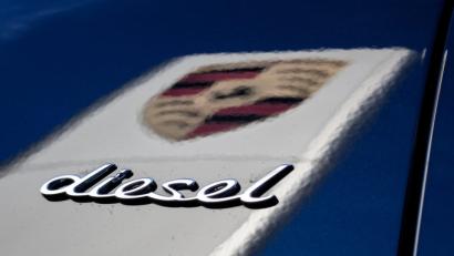 Bild: Christoph Schmidt/dpa
Das Logo des Fahrzeugherstellers Porsche in der dunklen Lackierung eines Porsche Cayenne, während dabei der Schriftzug "Diesel" auf dem Wagen zu sehen ist.