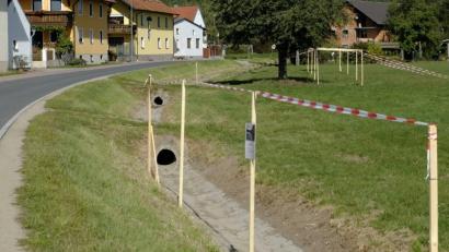Bild: ohr
Die Schutzlinie zieht sich (Blickrichtung von Norden nach Süden) entlang der Ortsdurchfahrt Brensdorf.
Im Hintergrund ist die Auspflockung des Deichquerschnittes mit einer Bauwerkshöhe von 2,26 bis 2,49 Meter zu sehen. Im Vordergrund ist ein Mauerabschnitt in der Höhe 2,25 bis 2,49 Meter simuliert.
