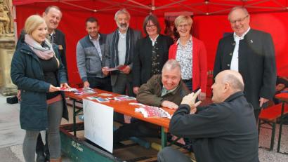 Bild: sön
Am Stand der Umweltstation des Klosters ließen sich von deren Leiterin Melanie Hahn (links) und Verwaltungsleiter Jürgen Zach (im Boot sitzend) Klosterdirektor Pater Christian Liebenstein, Bürgermeister Markus Dollacker (über den Tisch gebeugt), Barbara Hernes, Projektleiterin Seniorenmosaik, Isabel Lautenschlager, Geschäftsführerin Naturpark Hirschwald, Schirmherr Manfred Lehner, SPD-Kreisvorsitzender Uwe Bergmann und Bezirksrat Richard Gaßner (von rechts) informieren.