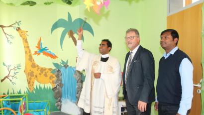 Bild: pi
Mit der Unterstützung von Pater Britto (rechts) segnet Pfarrer Julius Johnrose im Beisein von Bürgermeister Johann Maurer die neuen Räume der Krabbelgruppe.