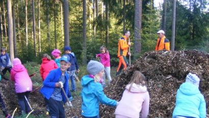 Bild: exb
Die Kombiklasse 2/3 der Grundschule Plößberg installiert mit zwei Förstern ein grünes Klassenzimmer im Wald nahe des Großen Weihers. Die Kinder dürfen mit mitgebrachten Werkzeugen selbst mitarbeiten.