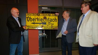 Bild: bgl
Theo Männer (Mitte) überreichte als Gastgeschenk dem Oberviechtacher Museumsleiter, Altbürgermeister Wilfried Neuber (rechts) ein altes Ortsschild als Wegweiser nach Oberviechtach Mit im Bild der ehemalige Lehrer Siegfried Bräuer (links).