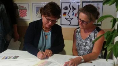 Bild: exb
Schulleiterin Irene Sebald (links) und Schulleiterin Patricia Morin (rechts) unterschreiben die Partnerschaftsurkunde.