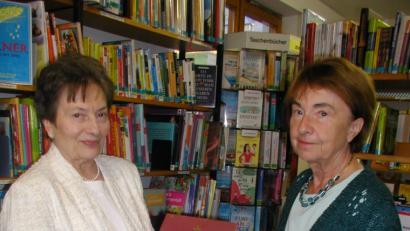 Bild: gis
Beim kleinen Empfang in der Bücherei
Leiterin Selma Markhof, rechts, und Namensgeberin des „Bücherstadls“ Marianne Specht zeigen das allererste Buch der Pfarrbücherei, "Vom goldenen Rom zur Welt". Es sollte in jeder Familie im Regal stehen. So wünschte es sich der damalige Pfarrer Anton Winkler.