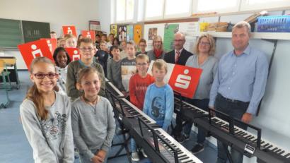 Bild: ibj
Mit den Schulkindern freuen sich Konrektor Stefan Ottmann und Fachlehrerin Regina Rester-Achhammer sowie die Sparkassenmitarbeiter Thomas Bieda und Kathrin Schmidt (von rechts) über die Spende.