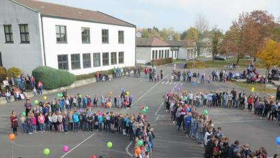 Bild: jzk
Am Ende des Schulfestes formieren sich die Grund- und Mittelschüler auf dem Pausenhof zur Zahl 50 und lassen bunte Luftballons in die Luft steigen.