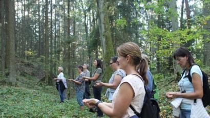 Bild: kmo
Theresia Nickl-Obermeier (Vierte von links) zeigt den Teilnehmern der AOVE-Veranstaltung Gaia-Touch verschiedene Wahrnehmungsübungen in der Natur.