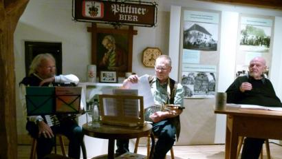Bild: rn
Nahezu zwei Stunden lang begeistert Schriftsteller Hans Günther Lauth, begleitet von den Musikern Walter Pilsak und Martin Betz (von rechts), bei den „Eschenbacher Mundarttagen“ die Zuhörer „beim Taubnschuster".