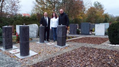Bild: e
Stelen werden bei der Bestattung weiterhin favorisiert. Bürgermeister Roland Strehl sowie Gerhard Büttner und Cornelia Büttner (Funeral Technique Hohenburg) sehen sich vor bereits bestehenden Stelen nach weiteren solcher Möglichkeiten im Kümmersbrucker Friedhof um.