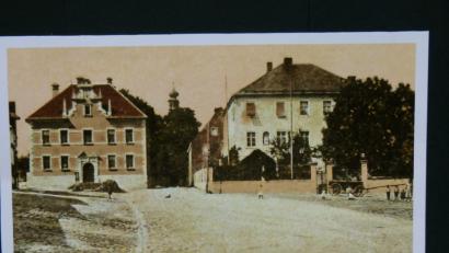 Bild: rn
Auf dieser Fotografie ist das Ensemble Vermessungsamt-Landratsamt (Bezirksamt) vor etwa einem Jahrhundert zu sehen. 50 Jahre vor Entstehung des Bildes gehört zum Gebäude auch noch das aus dem Jahr 1536 stammende Obere Stadttor mit der Wohnung des Stadttürmers. Aus Platzgründen und wegen angeblicher Baufälligkeit ist dafür am 31. März 1865 jedoch ein Abrissbeschluss der Königlichen Regierung erteilt worden. Der Abbruch zieht sich bis November 1867 hin.