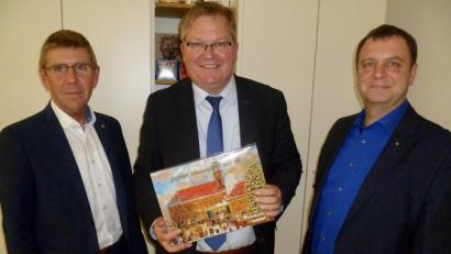 Bild: usc
Das erste Exemplar des diesjährigen Lions-Adventskalenders überreichten Club-Präsident Robert Jung (links) und Vizepräsident Andreas Hermann (rechts) an Oberbürgermeister Michael Cerny. Der Straßenverkauf auf der Krambrücke beginnt am kommenden Samstag.