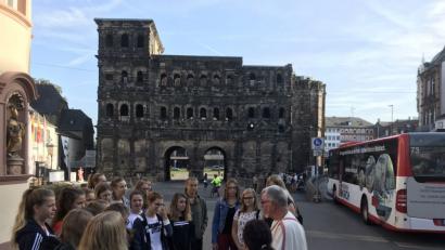 Bild: Michael Rösch/exb
Vor der Porta Nigra in Trier erfahren die Neuntklässlerinnen einiges über das römische Leben in Germania.