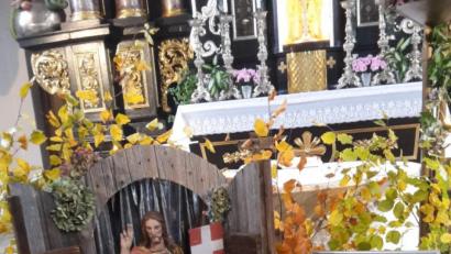 Bild: mng
Vor dem Volksaltar liegt, herbstlich dekoriert, das Totenbuch der Pfarrei. Dahinter thront die Figur des auferstandenen Jesus, zugleich als Zeichen der Hoffnung.