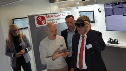 Bild: Bühner
Was eine Datenbrille leisten kann, davon überzeugte sich Oberbürgermeister Kurt Seggewiß bei der Auftaktveranstaltung von KMU meets 4.0. Mit dabei (von links) Dagmar Bock von der VHS-Firmenkundenbetreuung, Hendrik Walzel vom Mittelstand 4.0-Kompetenzzentrum Ausgsburg und VHS Geschäftsführer Stefan Frischholz