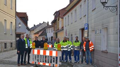 Bild: pjss
Bei der Sanierung der Ringstraße wurde die Wasserleitung bereits erneuert. Aktuell werden die Hausanschlüsse erstellt und das Pflaster erneuert. Bürgermeister Franz Stahl (links) stellte bei der Baustellenbesichtigung heraus, dass durch die Maßnahmen keine Kosten für die Anlieger entstehen.