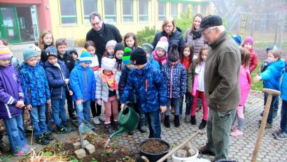 Bild: boj
Bei neugesetzten Pflanzen spielt das Gießen eine wichtige Rolle. Im Beisein von Dr. Werner Schuler (rechts), Bürgermeister Martin Prey, Rektorin Ortrud Sperl und Klassenleiterin Fiona Hauser-Kroner (hinten, von links) durfte ein Schüler dem Guten Heinrich einen ordentlichen Schluck Wasser verabreichen.