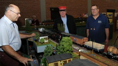 Bild: gfr
Bis ins kleinste Detail nachgebaut sind die Miniaturwelten. Das Bild zeigt den kurzzeitig mit roter Dienstmütze zum Fahrdienstleiter ernannten OB Michael Cerny und (rechts) Konstantin Ruhland, den Vorsitzenden des Modelleisenbahnclub Amberg am Bahnhof der Spur-1-Freunde aus Franken.