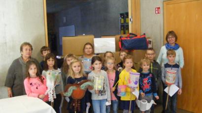 Bild: exb
Das Bild zeigt einige Schüler mit Laternen zusammen mit Amanda Schmidt-Castillo (rechts) und Rektorin Irmgard Wittmann (links) bei der Übergabe der Spendenpakete.