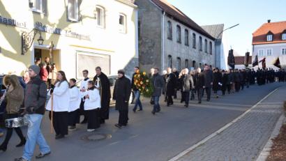 Bild: fla
Ein langer Trauerzug macht sich nach dem Gedenkgottesdienst auf den Weg zum Kriegerdenkmal. Die Markträte Georg Stahl und Michael Troidl (von links) tragen den Kranz, den sie später am Ehrenmal niederlegen.