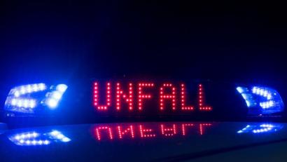 Bild: Monika Skolimowska
Das Blaulicht auf einem Fahrzeug der Polizei leuchtet in der Dunkelheit, auf dem Display ist der Hinweis „Unfall“ zu lesen. Foto: Monika Skolimowska/Archiv