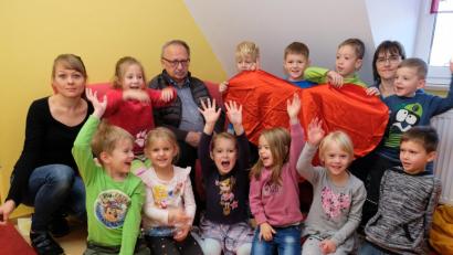 Bild: Dotzauer
Gut gelaunte Kinder nehmen bei der Spendenübergabe Andreas Steinl senior, den stellvertretenden Vorsitzenden der Kinderkrebshilfe Oberpfalz-Nord, in ihre Mitte. Symbolisch zeigen die Buben und Mädchen ein rotes Herz für schwerkranke Kinder und ihre Familien. Vertreterinnen des Personals der Kindertagesstätte freuen sich mit.