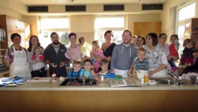Bild: ubb
Die jungen Eltern und ihre Kinder haben viel Spaß beim Kochen mit Diätassistentin Barbara Michalski (li.), die ihnen auch die Ernährungspyramide für gesundes Essen erklärt.