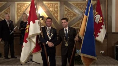 Bild: bey
Bürgermeister Rainer Rewitzer und Bürgermeister Petr Myslivec besiegeln den Austausch der Stadtfahnen mit Handschlag.