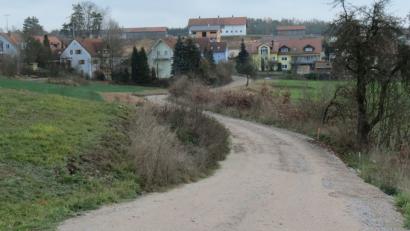 Bild: Köppl
„Am Kalvarienberg“ zwischen den Baugebieten „Am Hütberg“ und „Am Weinberg“ (im Hintergrund) plant der Markt linker Hand des geschotterten Notwegs die Ausweisung eines Baugebiets mit voraussichtlich fünf Bauparzellen.