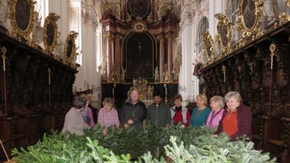 Bild: ubb
Mit vereinten Kräften und der Hilfe von Mesner Michael Burger und Kaplan John Gali haben die Frauen auch heuer wieder einen imposanten Adventskranz für die Basilika gebunden.