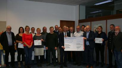 Bild: gpa
„Vereine und Institutionen rund um Eschenbach“, lautet der Titel des symbolischen Schecks über 5000 Euro, den Regionalmarktleiter Stefan Schedl (links) und Geschäftstellen- leiter Richard Götz in der Halle der Raiffeisenbank zeigen. Mit im Bild Vertreter der Vereine, die Spenden erhalten.