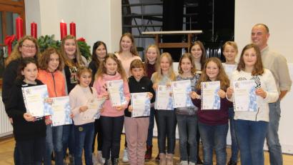 Bild: bph
Zusammen mit den Kindern der Bläserklasse16 und den frisch gekürten "Silberlingen" des Nachwuchsorchester freuen sich Bläserklassenleiterin Karin Raab (links) und musikalischer Leiter Markus Ferstl (rechts) über die guten Ergebnisse ihrer Schützlinge bei den Leistungsprüfungen.