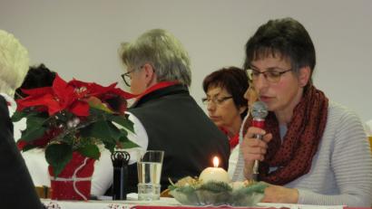 Bild: adj
An einem mit einem Weihnachtsstern und einer Kerze geschmückten Tisch liest Gertraud Mois die "Oberpfälzer Weihnacht".