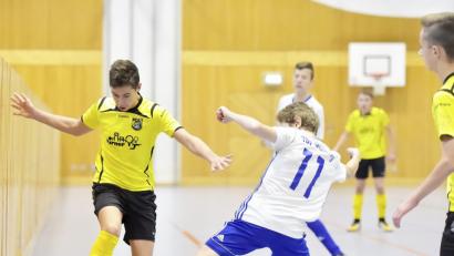 Bild: Hubert Ziegler
Mit dem Ball am Fuß läuft der Spieler des FC Amberg durch die Lücke zwischen Hallenwand und gestrecktem Bein des Gegenspielers vom TSV Großberg.