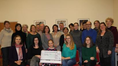 Bild: ads
.Anna-Lena (vorne, Mitte), jüngstes Mitglied des Familienchors Klangfarben, übergibt im Beisein von Chorleiterin Kataryna Menges (vorne, links) und den anderen Ensemblemitgliedern eine Spende über 600 Euro. Das Geld stammt aus dem Konzerterlös. Denise Frech (vorne, Zweite von rechts), Vorsitzende des Fördervereins Ninos Freunde, nimmt mit Stellvertreterin Jennifer Jobst (vorne, Zweite von links), den Scheck entgegen.