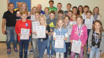 Bild: Heiko Schneider
Die erfolgreichen Sportler bei der Siegerehrung des Kids-Cups 2018 in Kümmersbruck mit den Jugendleitern des BTV-Bezirks Oberpfalz, Harald Kaunz (links) und Christian Betzlbacher (rechts daneben), dem Vorsitzenden des BTV-Bezirks Oberpfalz, Gerd Rucker (hinten, Fünfter von links), und Profi-Triathlet Sebastian Neef (rechts daneben).