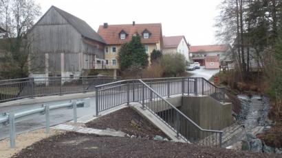 Bild: Brendel, Hubert (BR)
Die neue Brücke über die Creußen (Bild) ist nunmehr komplett fertiggestellt, auch wenn noch kleinere Restarbeiten erforderlich sind. Die Brückenbaumaßnahme war heuer ein Schwerpunkt bei den Investitionen der Gemeinde Schlammersdorf.