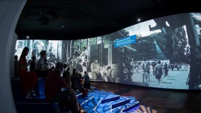 Bild: Paul Zinken/dpa
Besucher sitzen in der Alte Münze vor einer 270 Grad Leinwand. Dort können Besucher sich mit Bildern und Filmdokumenten über das Leben im ehemals geteilten Berlin informieren. Die Mediashow ist Bestandteil der Multimedia-Ausstellung "Nineties Berlin".