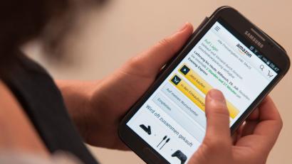 Bild: Sebastian Gollnow/dpa
Eine Frau bedient die Smartphone-App des Onlinehändlers Amazon.
