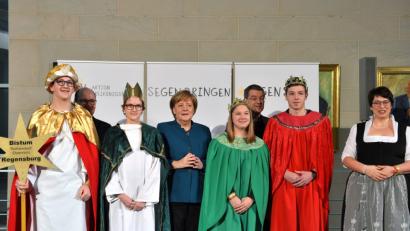 Bild: Ralf Adloff / Kindermissionswerk
Die Sternsinger Lisa (16), Moritz (15), Max (17) und Leonie (17) sowie Begleiterin Claudia Stöckl aus der Pfarrei St. Marien in Weiden-Rothenstadt vertraten das Bistum Regensburg am Montag beim Sternsinger-Empfang von Bundeskanzlerin Angela Merkel zur 61. Aktion Dreikönigssingen. Zum Gruppenfoto mit der Kanzlerin stellten sie sich gemeinsam mit Prälat Dr. Klaus Krämer, Präsident des Kindermissionswerks ,Die Sternsinger‘, und Pfarrer Dirk Bingener, Bundespräses des Bundes der Deutschen Katholischen Jugend (BDKJ), im Bundeskanzleramt auf.