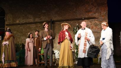 Bild:  Tobias Schwarzmeier
Kann eine alte Reisetasche, die Miss Prism (Waltraud Janner-Stahl, mit Peter Hösl) präsentiert, noch das Happy End für die Liebenden (Anna Kunz, Tobias Schäffler, Maximilian Hegner und Sophia Janner, Zweite bis Fünfte von links) retten? Die zynische Lady Bracknell (Brigitte Beer, links) scheint jedoch kaum umzustimmen zu sein. Tobias Schwarzmeier