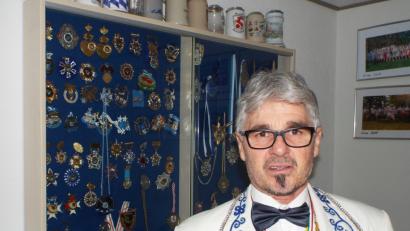 Bild: e
Streber heute vor Glasvitrine mit Ehrenzeichen des eigenen Vereins, die er "kistenweise" hat