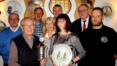 Bild: R. Kreuzer
Arnold Helgert (Zweiert von links) gewinnt das Kartellschießen. Die Vorjahressiegerin Heike Gmeiner (Dritte von rechts) übergibt die neue Scheibe, die Adi Bogner zum letzten Mal gestaltet hat.