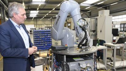 Bild: Petra Hartl
Karl Ebnet ist seit 1996 bei Baumann Automation. Seit einigen Jahren ist er nun Geschäftsführer. Hier steht er neben einem selbstfahrenden Roboter, der zu automatischen Bestückung von Anlagen eingesetzt ist.