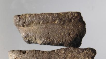 Bild: ken
Eine Randscherbe und eine Wandscherbe aus Graphitton. Dabei wurde Graphit dem Ton beigemengt, um so einerseits größere Hitzebeständigkeit zu erreichen, andererseits dem Gefäß ein metallenes Aussehen zu geben.