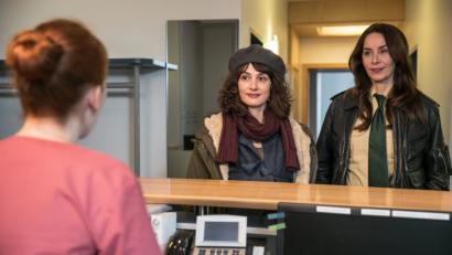 Bild: Bild: ARD/TMG/Chris Hirschhäuser
Sabine Kaiser (Katharina Müller-Elmau, rechts) begleitet Elke Becker (Anastasia Papadopoulou, Mitte) zum Frauenarzt, wo sie von Sprechstundenhilfe Liesl Wolpert (Christina Baumer) empfangen wird. .